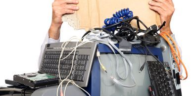 Persona frustrada con muchos equipos informáticos y cables.