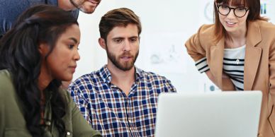 Grupo de personas colaborando frente a una computadora.